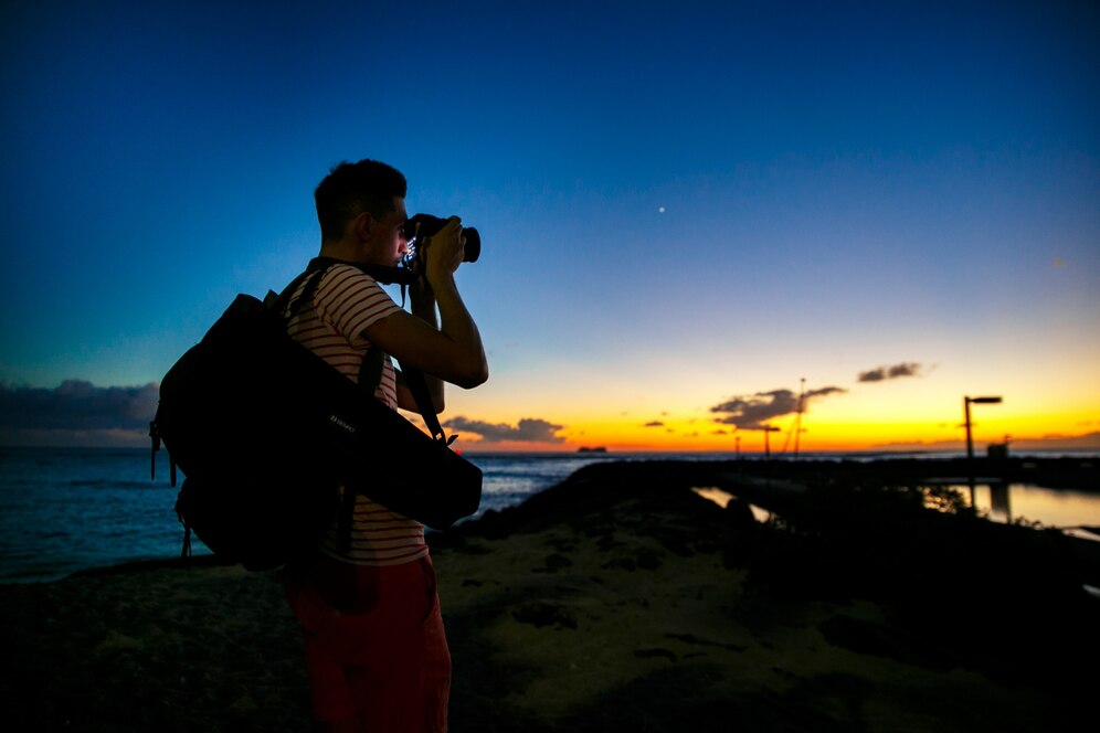 photographer-stands-with-camera-shore-with-great-evening-sky-him_1304-5307